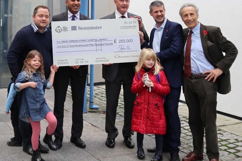 Bill Henderson MLC and his daughter Sophia, in red coat, are pictured at Great Ormond Street Hospital on Thursday with, from left, Tower Mint director Elliot Dawson and his daughter Olivia, Director of Corporate Partnerships at GOSH Amit Aggarwal, Ian Glen from Westminster Collections and Tower Mint chairman Raphael Maklouf